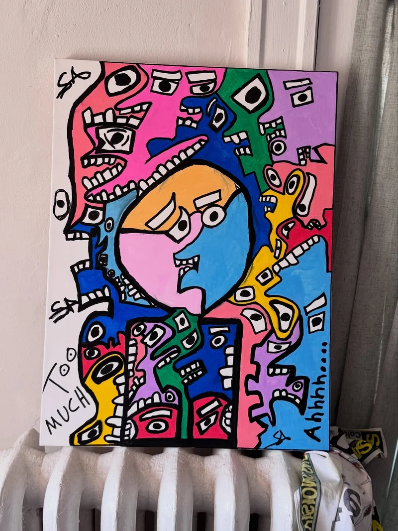 A crowd of faces in flat pink, green, purple, blue, yellow, and red, each drawn in thick black outline with blocky white eyes and bared square teeth, pressing in on one larger calm face at the centre in orange, pink, and blue. Too Much is lettered down the lower left and Ahhhh along the lower right.